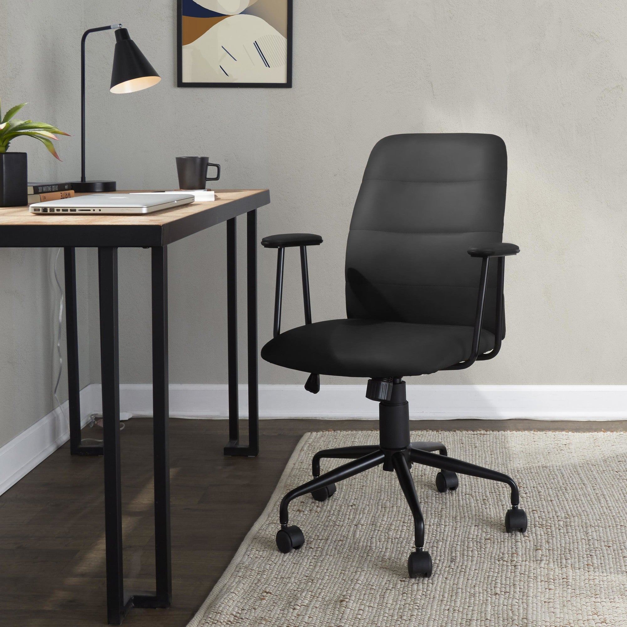 Black faux leather swivel office chair at a home office desk