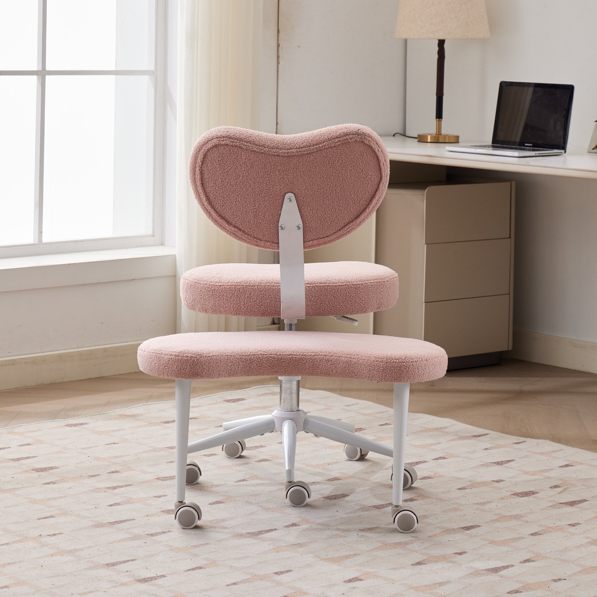 Pink cross-legged meditation chair on wheels with lumbar support in a home workspace, plus-size.