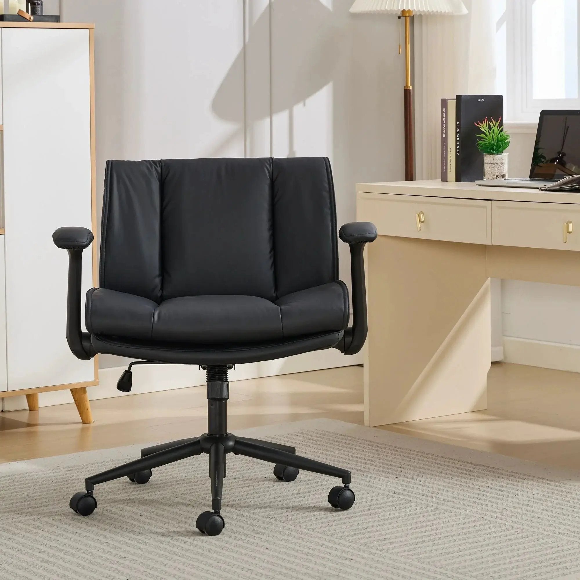Black leather ergonomic cross-legged chair by Doba with adjustable flip-up armrests and black metal frame.