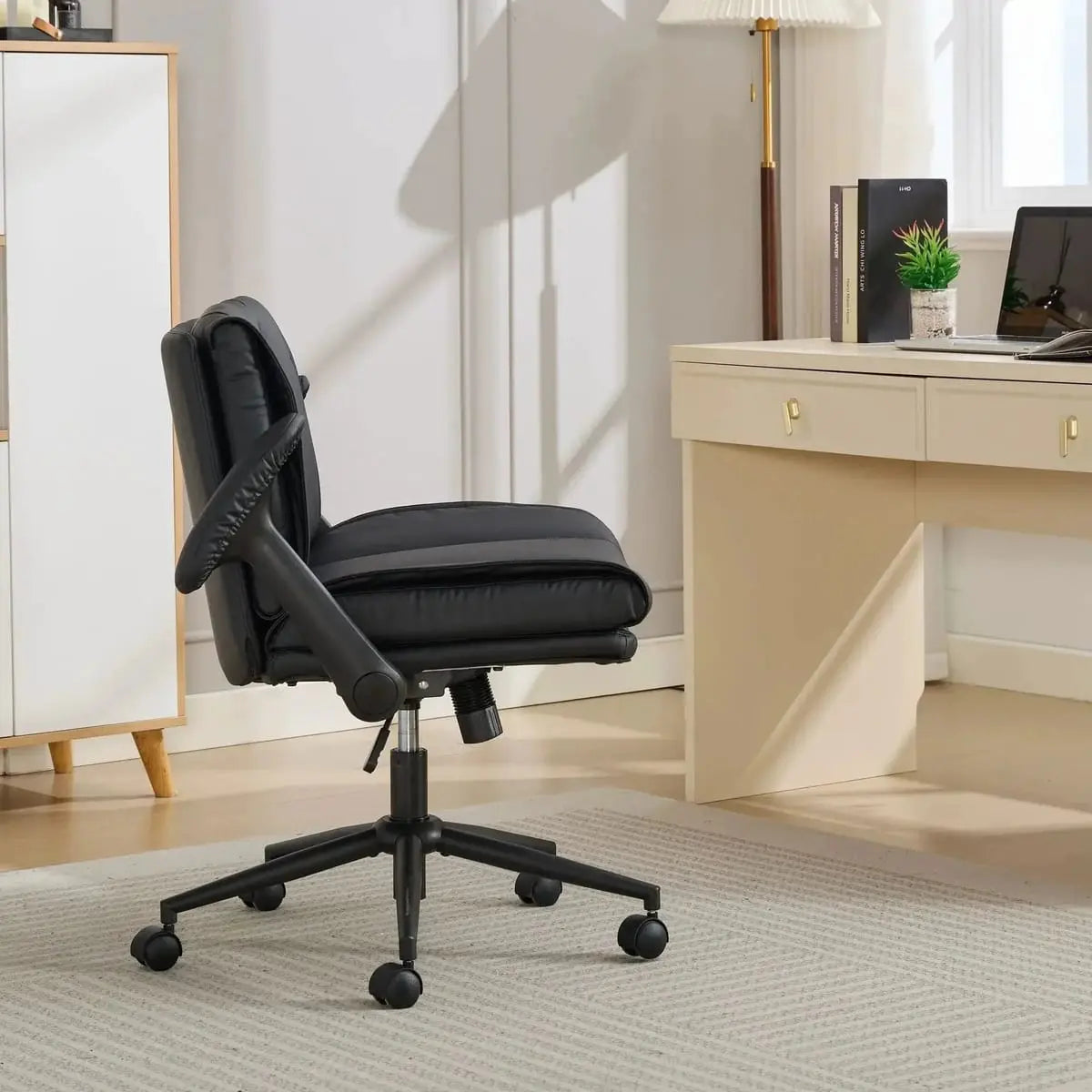 Doba ergonomic black leather cross-legged chair with adjustable flip-up armrests and black metal frame, side view.