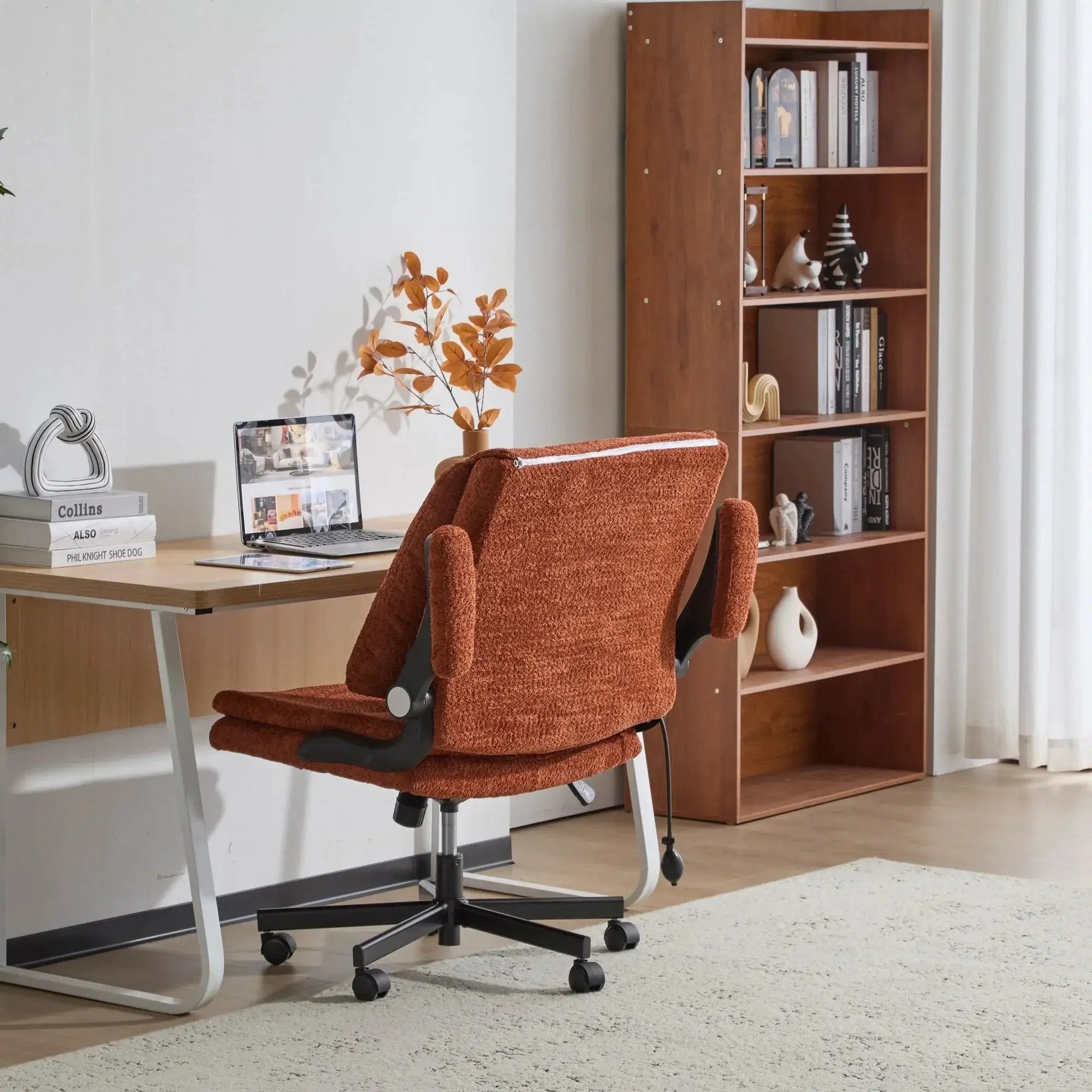 Orange Doba ergonomic criss-cross desk chair with flip-up back and arms, featuring a nylon seat and adjustable support.