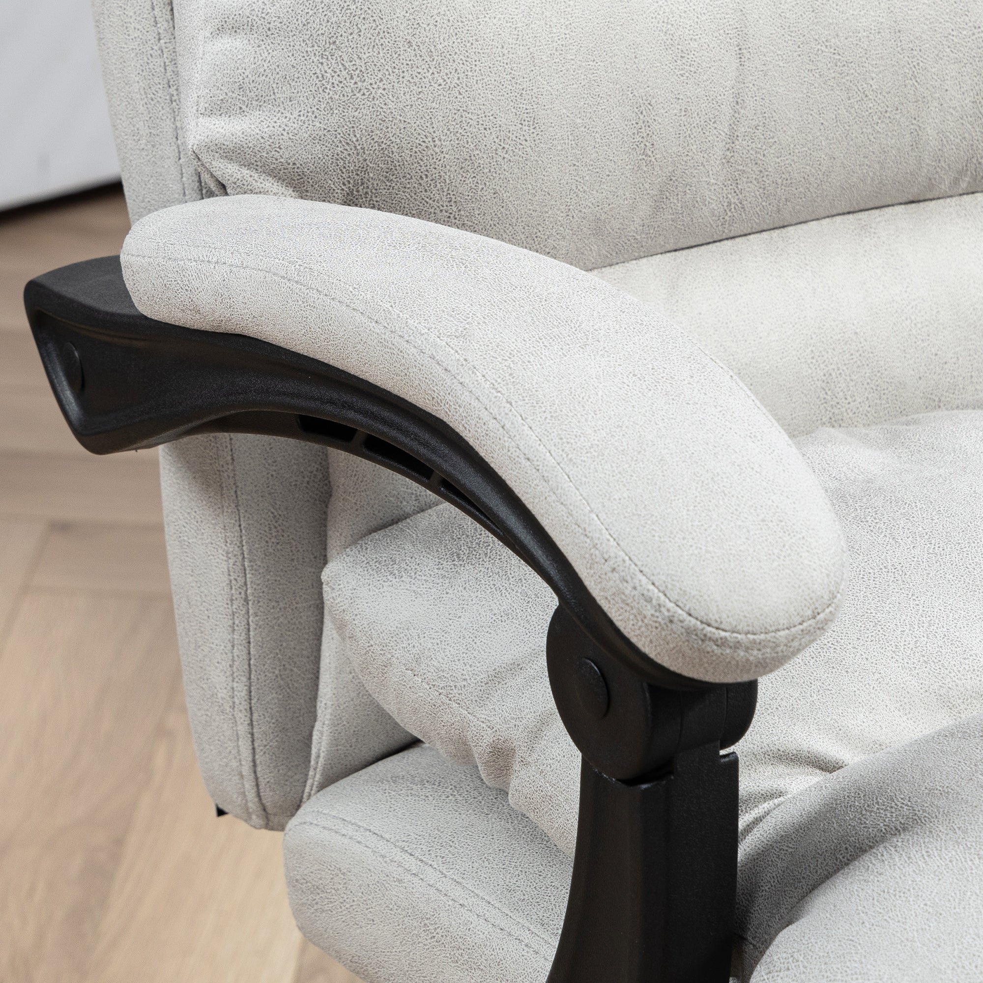 Close-up of padded armrest on light gray office chair