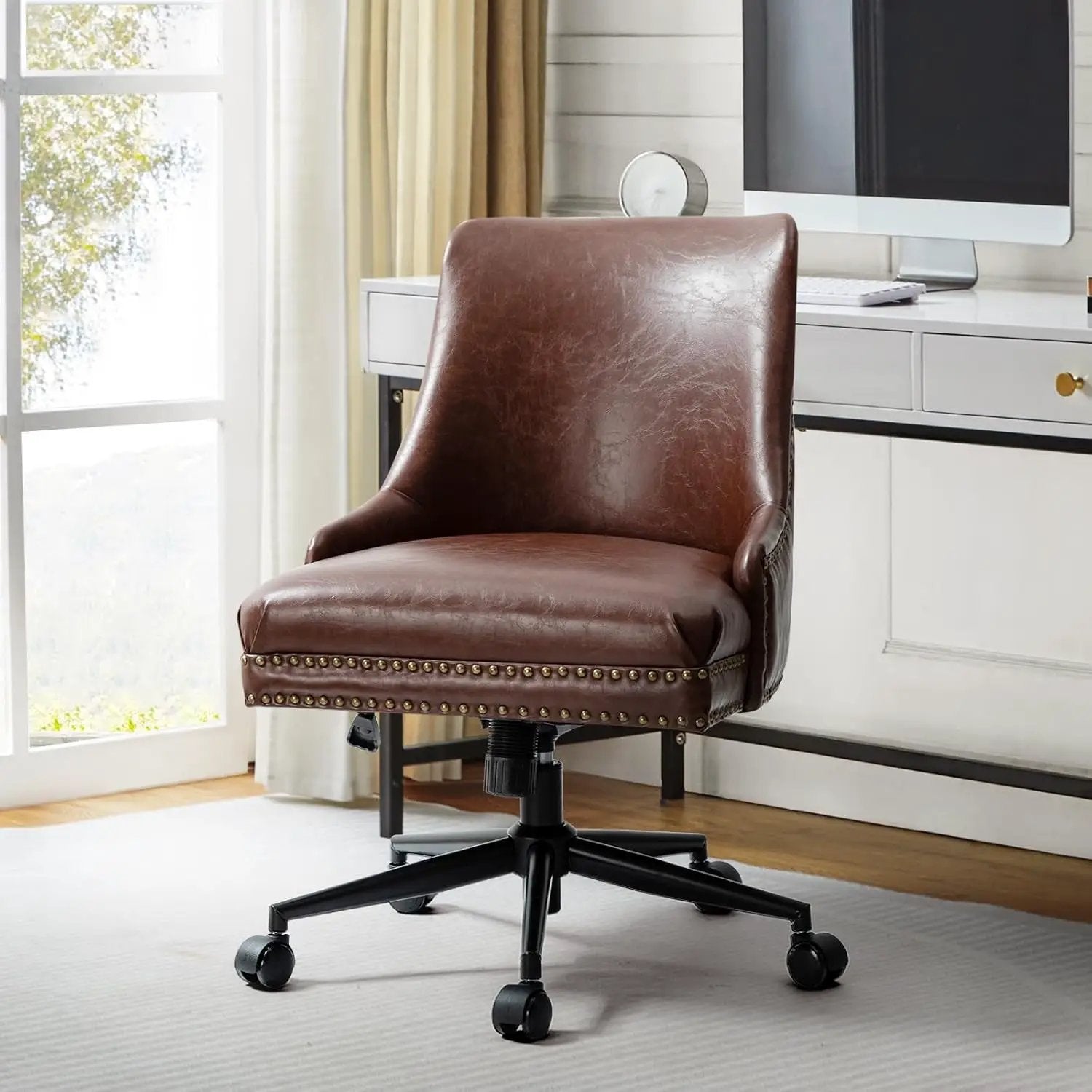 Faux leather office chair in brown with nailhead trim and black metal base on casters