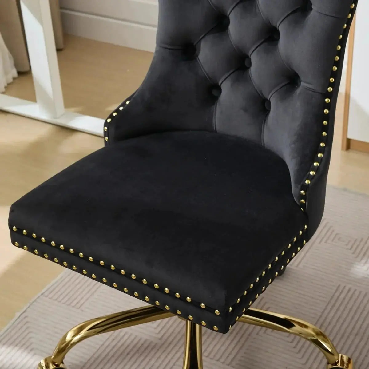 Luxurious black velvet tufted office chair with gold electroplated base, deep seating, ergonomic design, and nailhead trim.