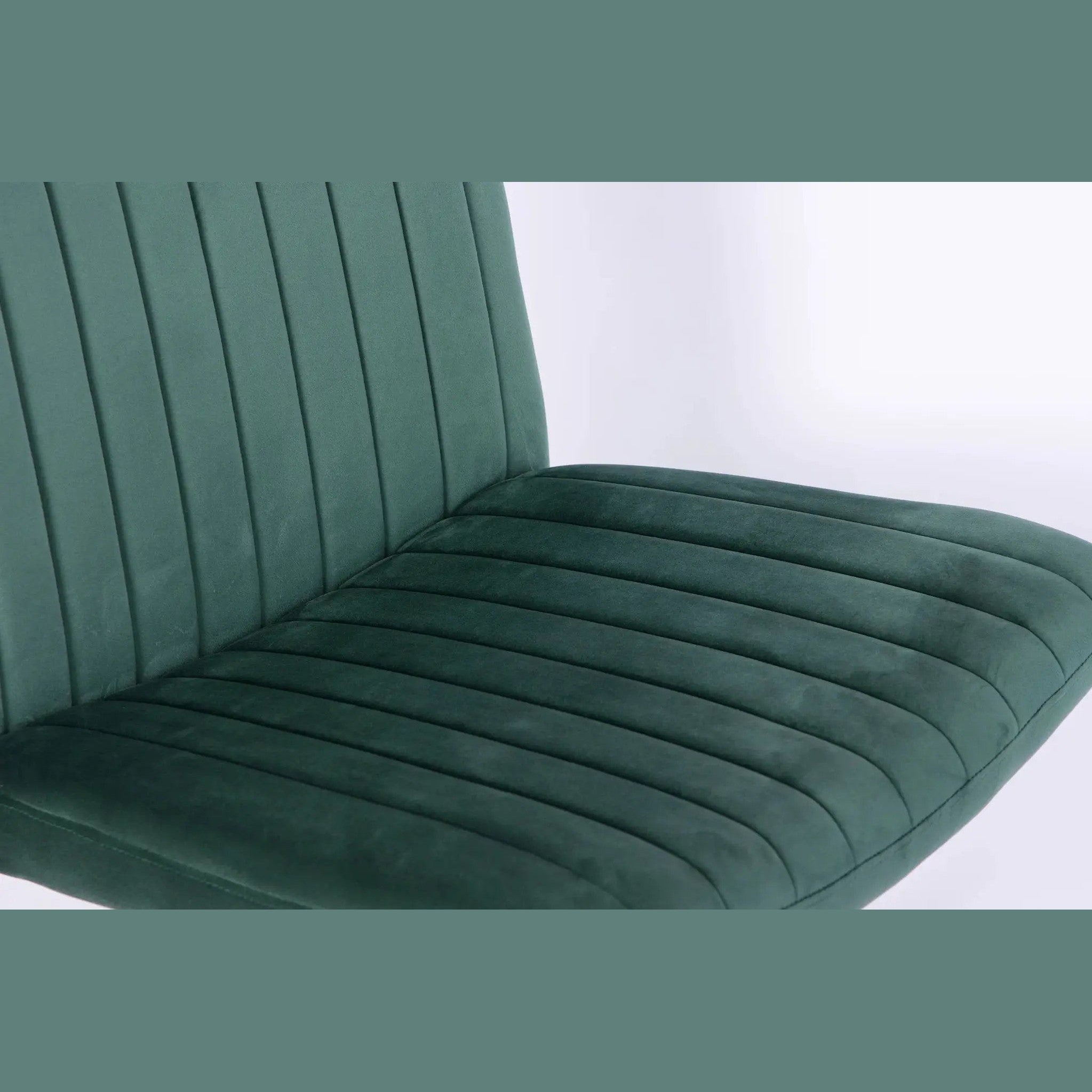 Green velvet armless office chair with criss-cross design, ergonomic shape, wheels, and platinum-level branding.